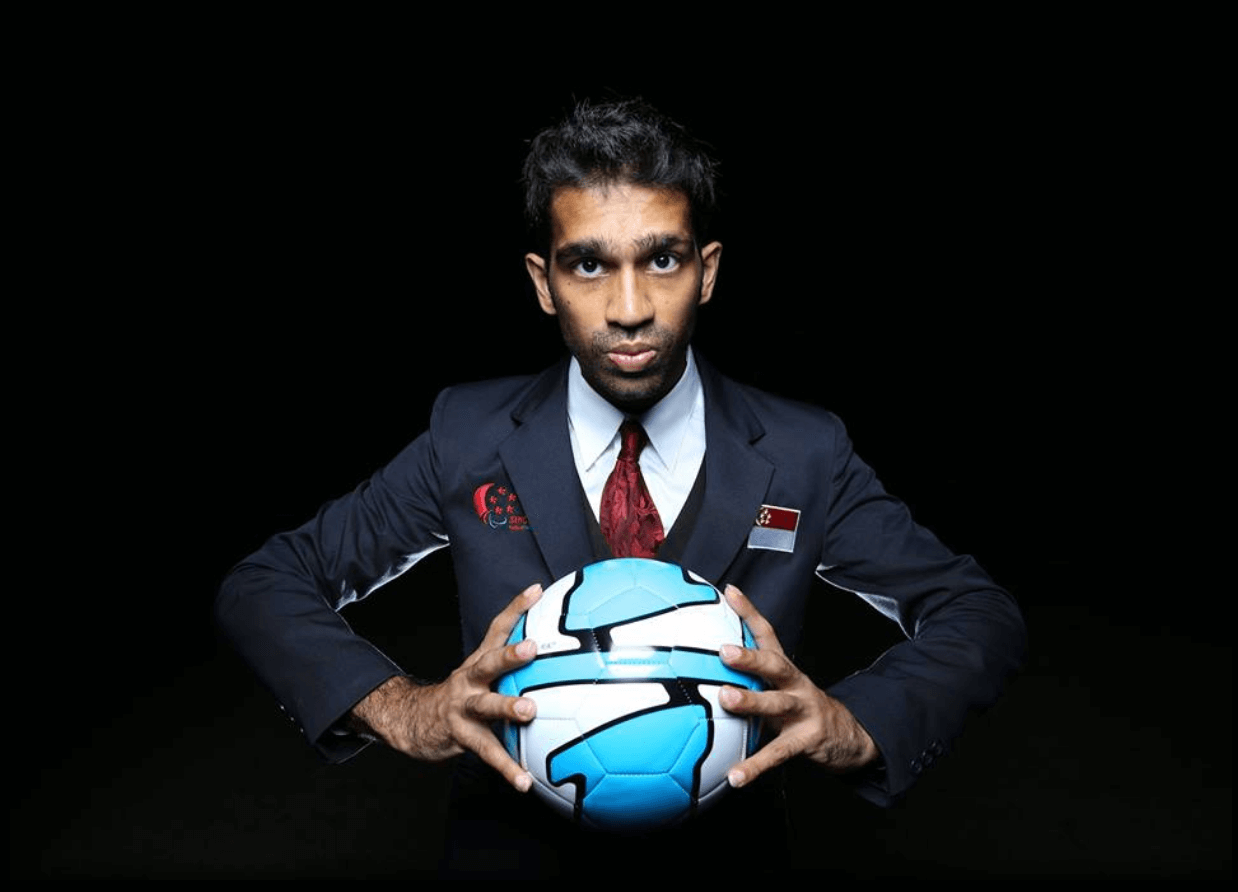 Hitesh Ramchandani: A man wearing a 3-piece suit and tie holding a physical therapy ball between his hands.