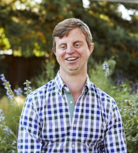 Image of Dr. Hoby in a print shirt. He is a white man, is blonde and is smiling.